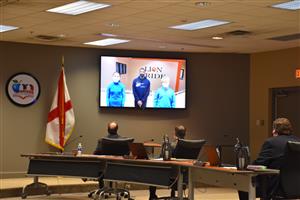 Video on big screen in board room with BOE members watching 